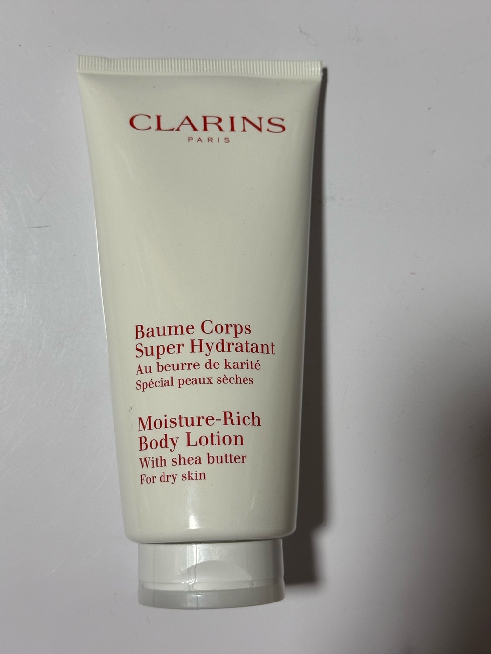 Clarins Moisture-Rich Body Lotion - Cream with Red Text